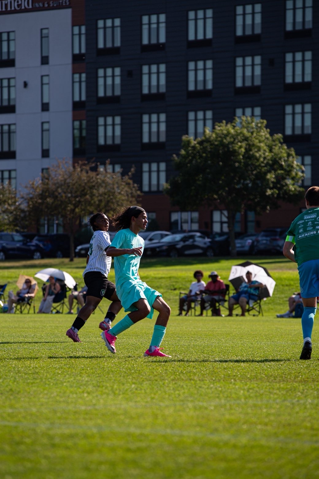 Soccer player sprinting past a defender in evening light